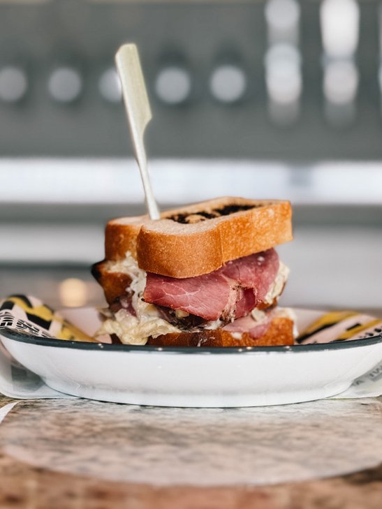 Broodje pastrami op een emaillen bordje